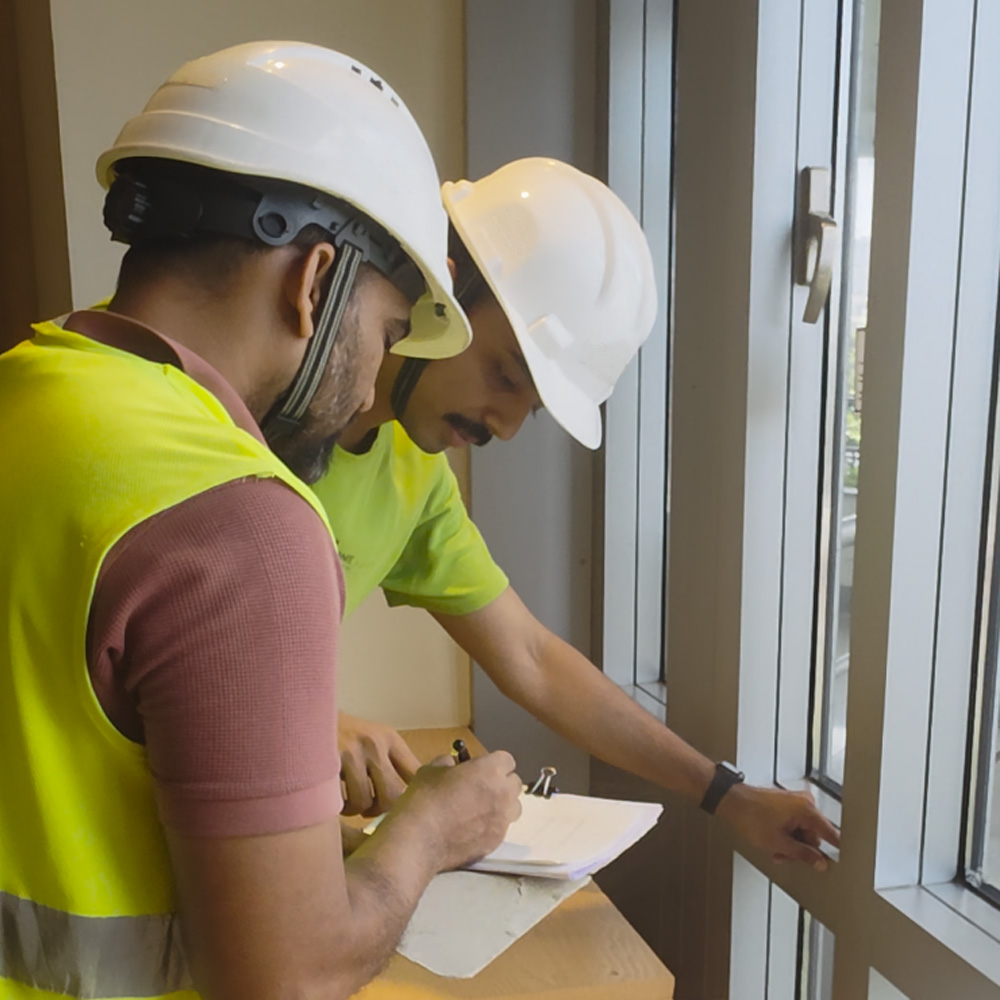 Physical field survey of a building facade by technicians